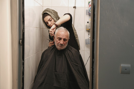 Massoumeh coupe les cheveux de son päre dans son salon situÇ dans le quartier Shoush au sud de TÇhÇran dans le film Salon de beautÇ de Shiva Sanjari ∏ ALEGRIA PRODUCTIONS